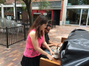 People playing outside pianos.