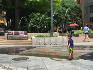 Children frolicking in fountains.